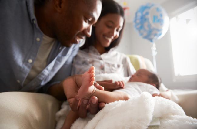 A mother and father looking at their newborn