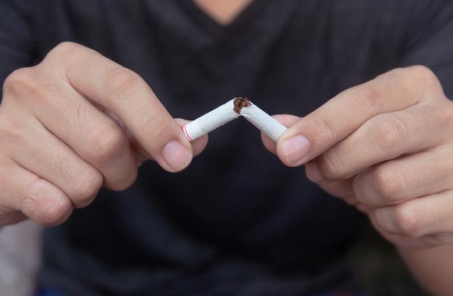 hands breaking a cigarette in half