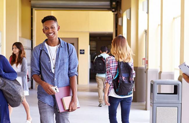 Young teens walking in school hallway