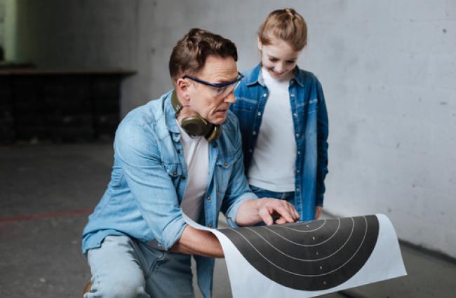 Image of man and child looking at a target.