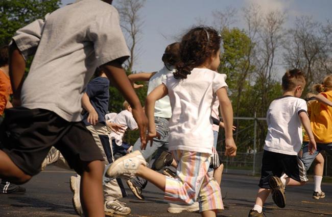 Image of children running through playground.