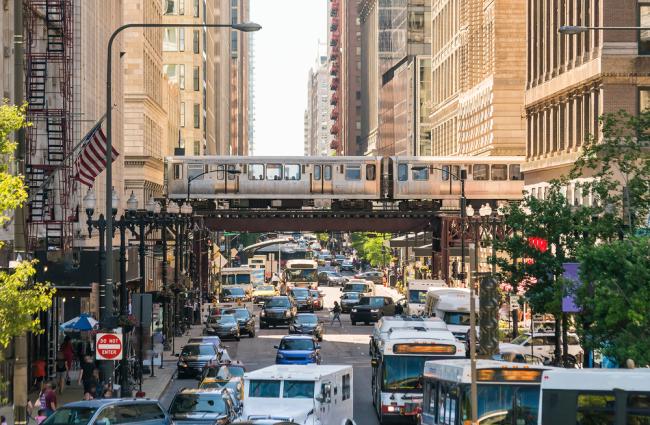 Traffic in downtown Chicago with people, train, cars, and buses