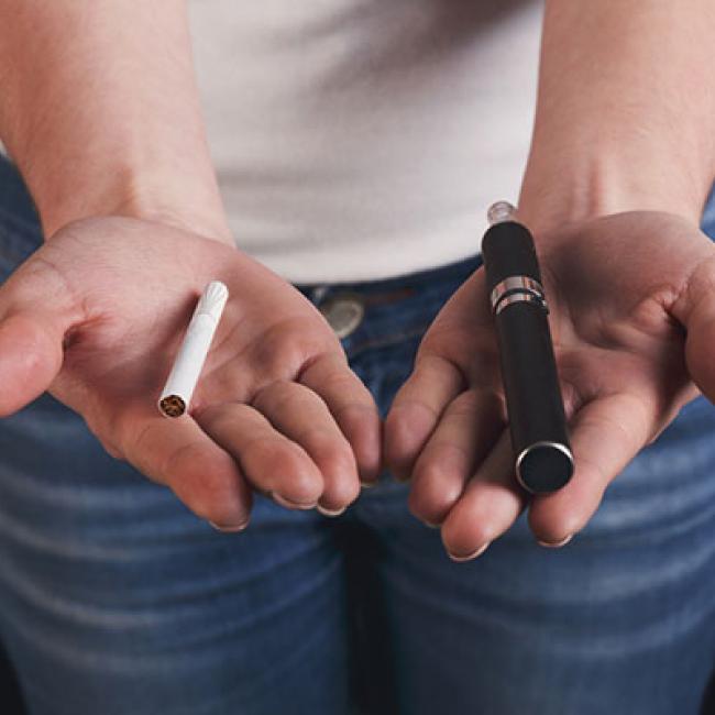 hands holding a cigarette and vaporizer