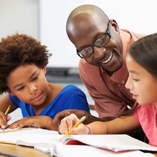 Teacher helping students at their desk