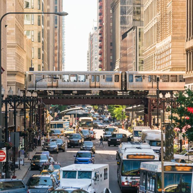 Traffic in downtown Chicago with people, train, cars, and buses