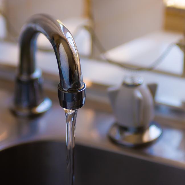 Faucet with running water into a sink