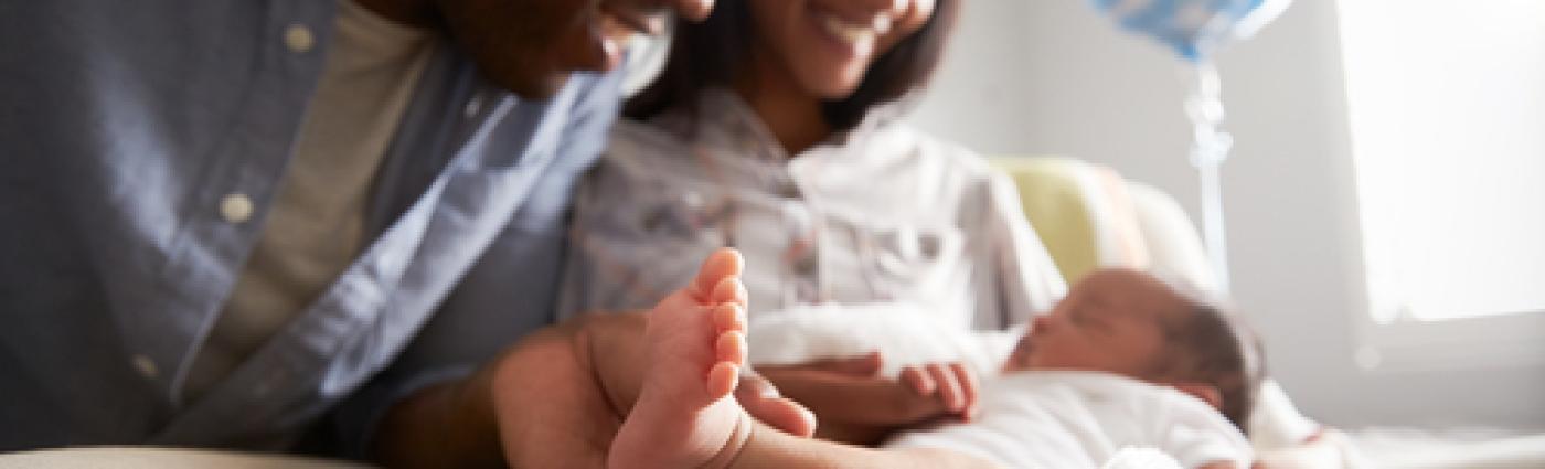 A mother and father looking at their newborn