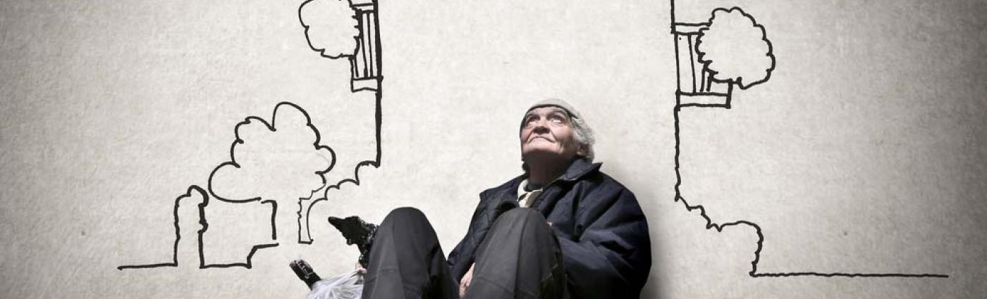 Homeless person leaning agains a wall