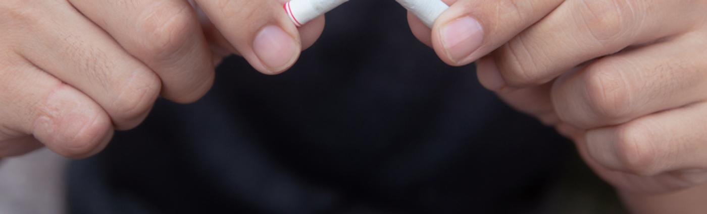 hands breaking a cigarette in half