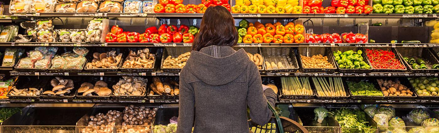Woman looking at produce in grocery store