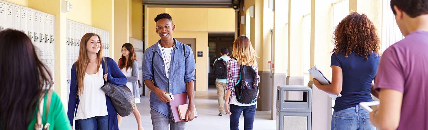 Young teens walking in school hallway