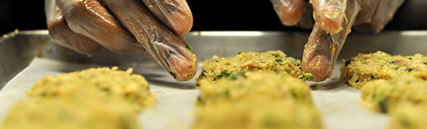 Image of a person in gloves preparing food.