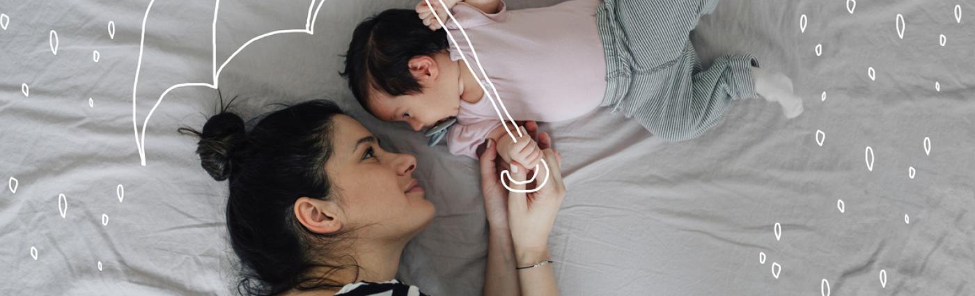 Woman and baby lying on a bed with an illustration of an umbrella over them shielding them from rain