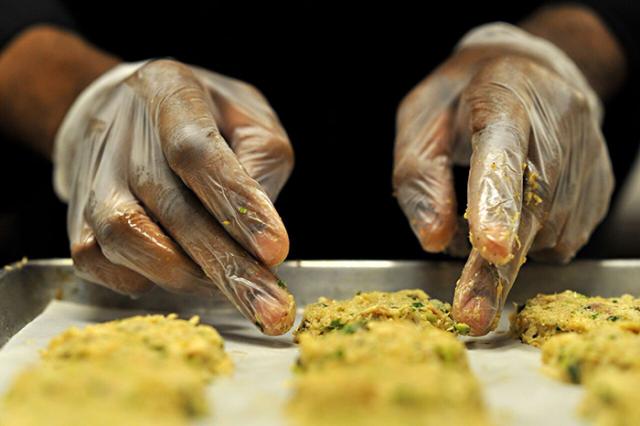 Close up of hands working some dough on a cookie sheet