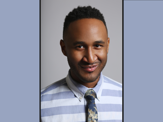 Terrell Winder, a smiling Black man with a blue and white striped button down shirt and a dark floral patterned tie