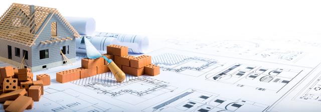 Model house being constructed on top of a set of blue prints