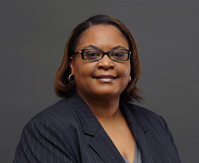 Dr. Melody Goodman, a Black woman with shoulder length brown hair wearing glasses, a blazer, and earrings